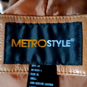 A tan leather maxi coat with tags attached